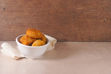 Circle chicken nuggets in white bowl on wooden background on a wooden background. Nugget Lingkaran