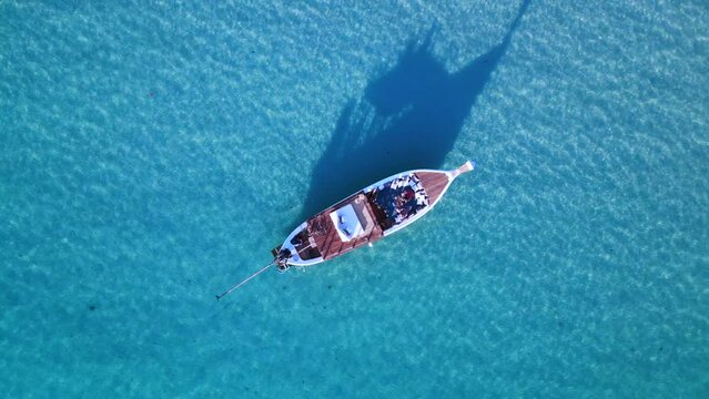vip boad in crystal clear water long shadow Perfect aerial top view flight drone