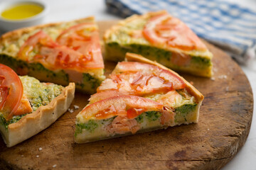 French style quiche with broccoli, salmon, and slices tomato.