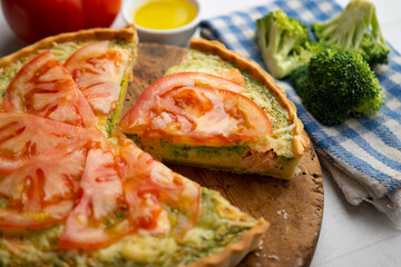 French style quiche with broccoli, salmon, and slices tomato.
