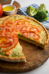 French style quiche with broccoli, salmon, and slices tomato.