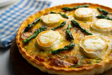 French style quiche with green asparagus, eggs, and slices of goat cheese.