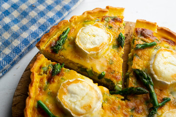 French style quiche with green asparagus, eggs, and slices of goat cheese.