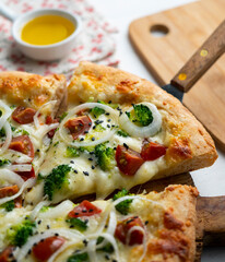 Neapolitan pizza with cheese, onion, broccoli and cherry tomatoes.