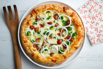 Neapolitan pizza with cheese, onion, broccoli and cherry tomatoes.