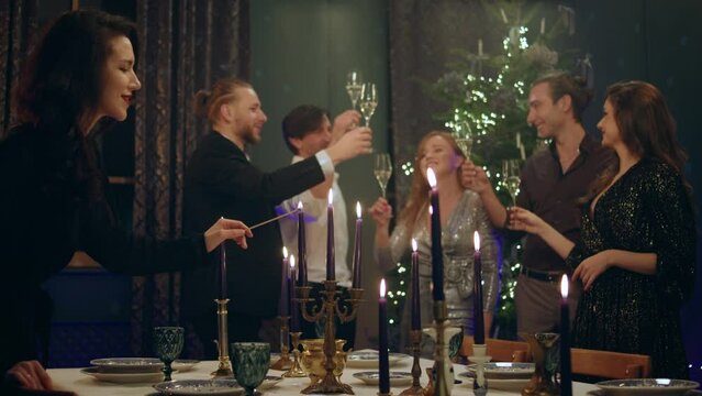 Concept of Christmas atmosphere at home group of good friends very charismatic and attractive celebrating together the Christmas night they drinking champagne beside the Christmas tree one lady very