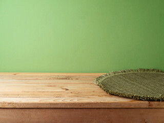 Empty wooden table with place mat over green wall background. Christmas mock up for design and...