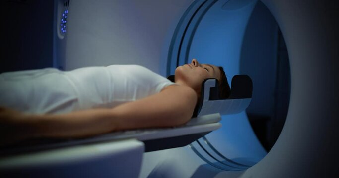 Portrait of Woman Lying on a Bed of CT or PET or MRI Machine, Undergoing a Brain Scan Procedure. Technologically Advanced and Functional Medical Equipment in a Clean White Room