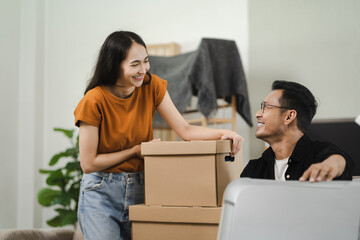 young couple helps young couple helps put things in boxes and prepares to move to a new house.ut things in boxes and prepares, smiling happy moving to a new house.