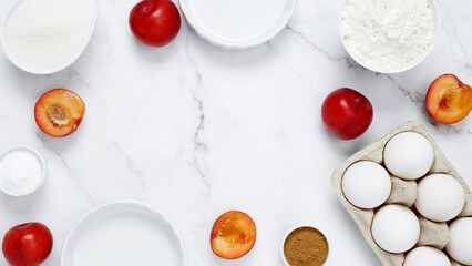 Ingredients for making classic cake pie with plums on white background. Concept homemade food,...