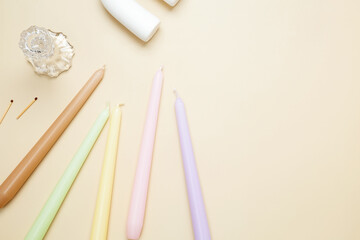 Set various antique long candles on a beige background. Top view, copy space, flat lay