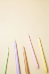 Set various antique long candles on a beige background. Top view, copy space, flat lay