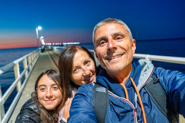 Happy family relaxing at sunset on Busselton Jetty, Western Australia