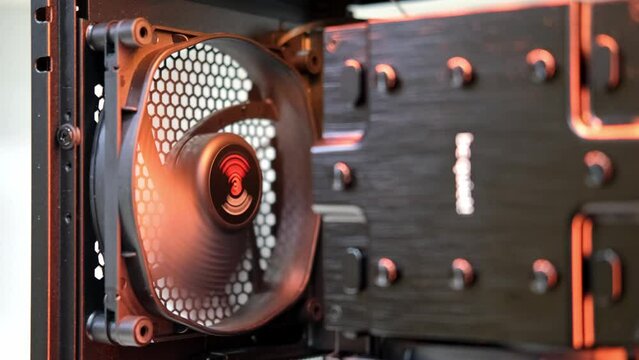 The fan rotates slowly in the case. An integral part of a computer, a spinning fan. Cooling system. Computer equipment, assembly and repair, IT