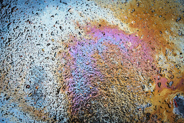 Leakage of oil or gasoline from a car onto a wet asphalt road. Environmental pollution concept