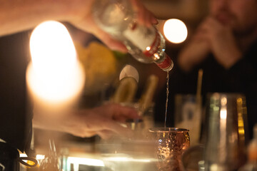 The bartender pouring vodka in the mixer