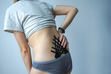 Girl with lower back pain, treatment of vertebral displacement, hernias and protrusions with tapes.