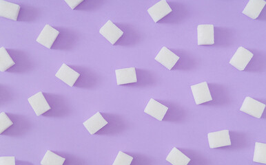 Creative pattern made of sugar cubes on pastel violet background. Minimal food concept. Trendy flat lay pattern background composition. Fancy sugar cubes idea. Top of view.