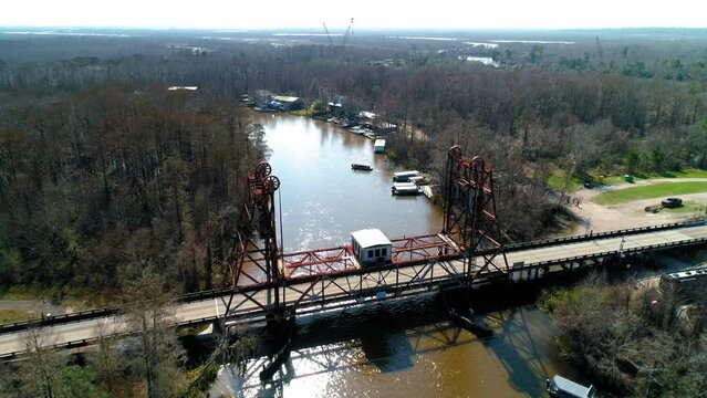 Aerial Forward Shot Of Vehicles On Bridge Over River Amidst Trees Against Sky - New Orleans, Louisiana