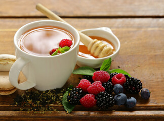 natural tea in a cup with fresh berries and mint