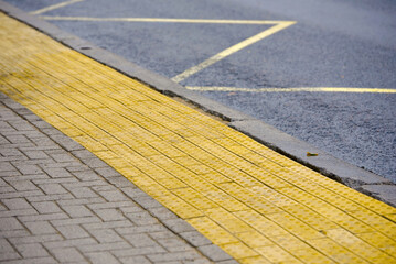 Tactile paving on bus stop, Yellow blocks for blind handicap on tiles pathway, walkway for...