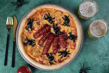 Halloween pizza with sausage fingers and spiders, Creative idea for Halloween on green background