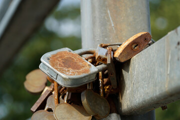 Many rusty padlocks closed on bridge fence - love concept