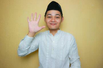 an Indonesian Muslim man of Asian descent wearing Muslim clothes and a black peci, celebrating Eid...