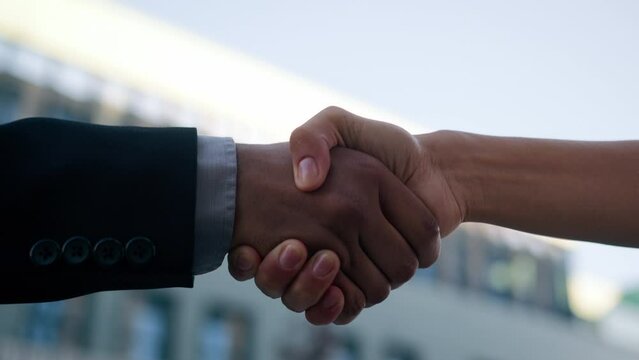 Closeup two people diverse multiracial man woman shake hands conclude successful contract agreement support partnership cooperation businessman and businesswoman greet on street business handshaking