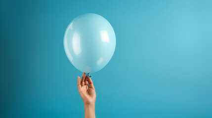 hand holding a blue balloon on a blue background. woman's hand holding a balloon. gender reveal balloon. birthday party. festival. balloon for mockups.