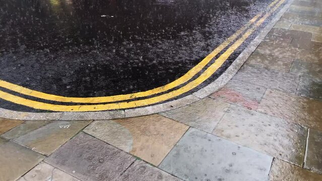 Heavy torrential rain downpour in the City of London, covering roads and pavements. Concept for wet weather, climate change, global warming, storms, environment  and flooding. Static shot rain drops.
