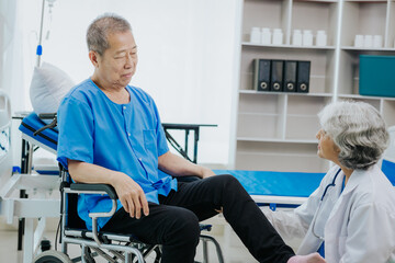 Asian female physical therapist works with an elderly woman to walk with a walker.