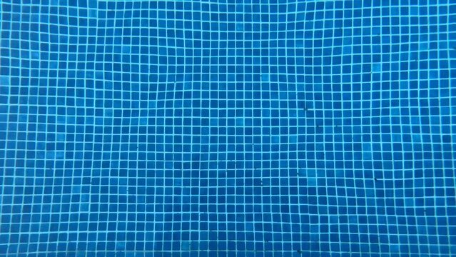 Blue mosaic coated swimming pool with small water ripples