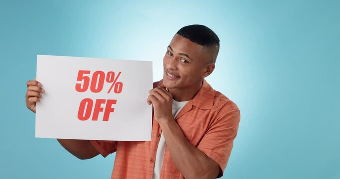 Sale, poster and face of happy man in studio with yes discount, deal or announcement on blue background. Billboard, promo code and portrait of guy model with retail, banner or news, offer or cashback