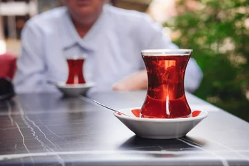 Poster Turkish tea in a traditional glass on a table in a cafe  © Надежда Филатова