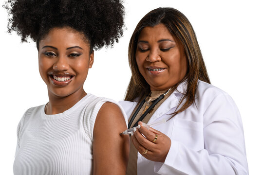 teenage girl being vaccinated in the arm looks at the camera and smiles, health professional vaccinating, 