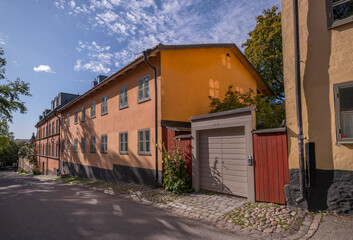 Fototapeta na wymiar Old houses and a wood entrance doors in the district Södermalm, cumulus clouds, a sunny autumn day in Stockholm