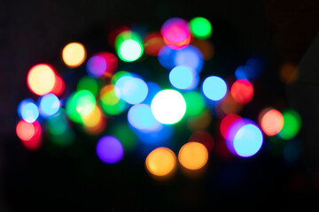 Festive Christmas and New Year background with bokeh, blurred lights on black background