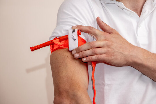 A healthcare worker demonstrates how to apply a tourniquet to the arm to stop bleeding in case of injury or accident