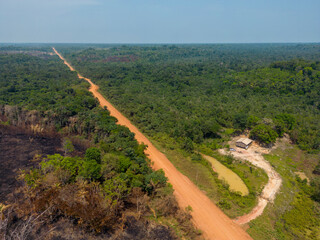 Drone shot of the famous BR-319 in dry season, a dirt road through the Amazon rainforest between...