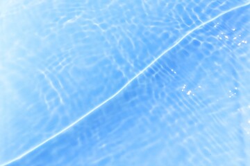 Defocus blurred transparent blue colored clear calm water surface texture with splashes reflection. Trendy abstract nature background. Water waves in sunlight with copy space. Blue watercolor shine.