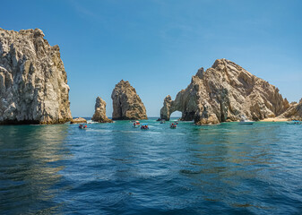 Mexico, Cabo San Lucas - July 16, 2023: El Arco rocky arch at Reserva de Lobos Marinos. Passage from ocean to bay with plenty of small sightseeing boats up front