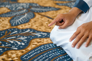 Muslim men praying in Tashahhud posture