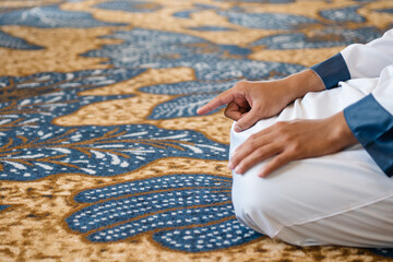 Muslim men praying in Tashahhud posture