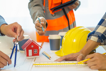 Construction engineer. businessman engineer Meet in the office to discuss building design for the client. 3rd male engineer designs house structure on table in office