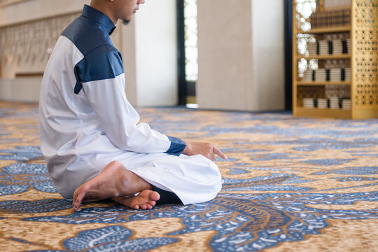 Muslim men praying in Tashahhud posture