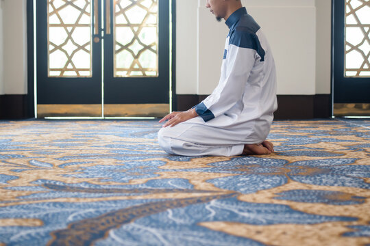 Muslim men praying in Tashahhud posture