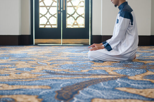Muslim men praying in Tashahhud posture