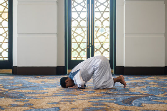 Muslim men praying in sujud or prostration posture