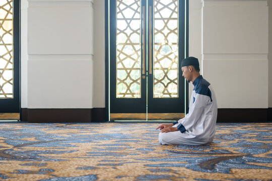 Muslim men praying in Tashahhud posture